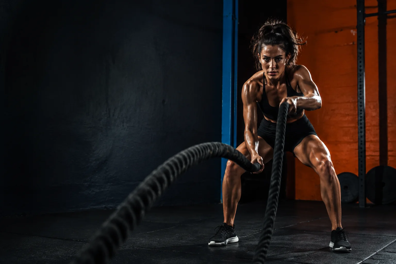 Atleta entrenando con cuerdas en un gimnasio urbano